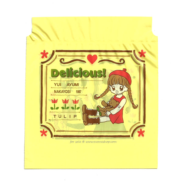 small yellow bag featuring an image of an anime girl with a teddy bear from the 90s manga Delicious!