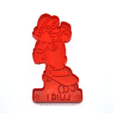 Vintage 1989 red plastic cookie cutter of  Luigi from the Super Mario Brothers games riding a skateboard.