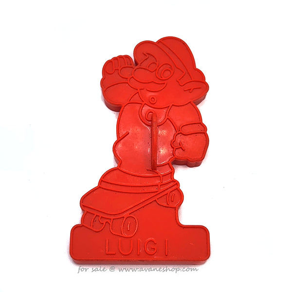 Vintage 1989 red plastic cookie cutter of  Luigi from the Super Mario Brothers games riding a skateboard.